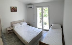 a bedroom with two beds and a window at House Mima in Pag