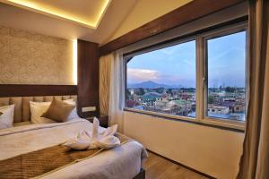 a bedroom with a large window with a view of a city at Trillium Hotel by Stay Sphere in Srinagar