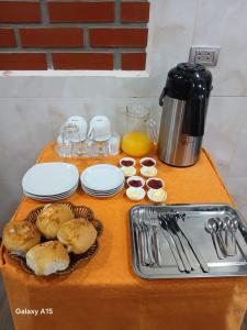 a table with plates and utensils and food on it at Qamana Soto S in Uyuni