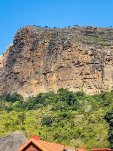 a mountain in the background with a building in front at N'taba River Lodge & Spa in Port St. Johns