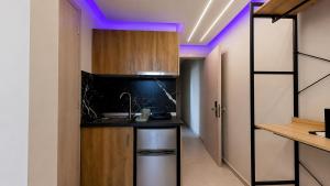 a kitchen with a sink and a counter with purple lights at Troy Seaside in Paralia Katerinis