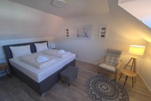a small bedroom with a bed and a chair at Casa Claudio in Plau am See