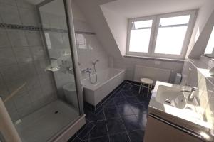 a bathroom with a shower and a tub and a sink at Casa Claudio in Plau am See +10 photos