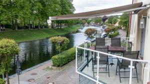 a balcony with tables and chairs next to a river at Casa Claudio in Plau am See