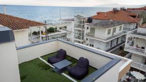 a balcony with two chairs and a table and the ocean at Troy Seaside in Paralia Katerinis