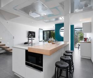 a kitchen with white walls and a counter with stools at Villa Marina N173 - 5P6 in Le Grau-du-Roi