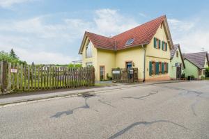 a yellow house with a red roof on a street at Europa Park, Zimmer mit eigenem Bad in Herbolzheim