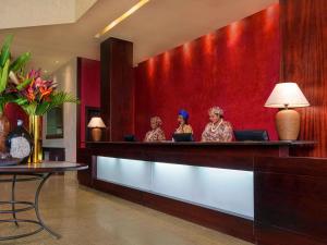 three women sitting at a bar in a hotel lobby at Mövenpick Hotel Ikoyi Lagos in Lagos +77 photos