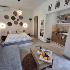 a living room with two beds and a table with a tray of fruit at Sky Rooms in Nea Kallikrateia
