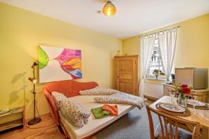 a living room with a bed and a table with a tableablish at Europa Park, Zimmer mit eigenem Bad in Herbolzheim
