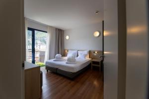 a hotel room with a bed and a window at Hi Hotels Riva del Garda in Riva del Garda +177 photos