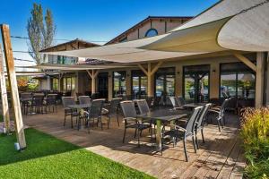 a patio with tables and chairs and an umbrella at Duna Garden Hotel in Budapest