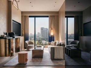 a living room with a couch and a large window at Mondrian Singapore Duxton in Singapore