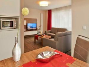 a living room with a couch and a table with a vase at Dünenhaus Aurell, App 4 mit Sauna in Heringsdorf
