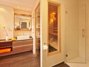 a bathroom with a sink and a glass shower at Dünenhaus Aurell, App 4 mit Sauna in Heringsdorf