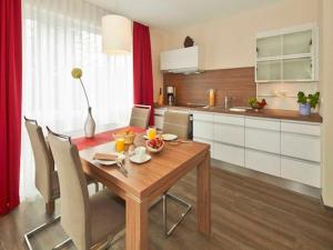 a kitchen with a wooden table with chairs and a dining room at Dünenhaus Aurell, App 4 mit Sauna in Heringsdorf