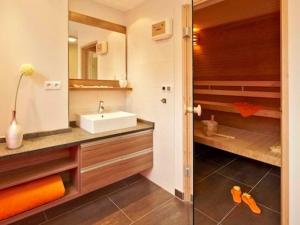 a bathroom with a sink and a shower at Dünenhaus Aurell, App 4 mit Sauna in Heringsdorf +11 photos