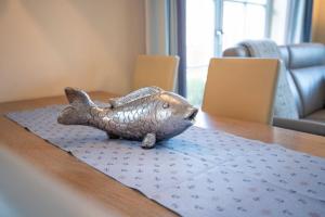 a statue of a fish sitting on a table at Ferienhaus Strandmuschel mit Sauna in Loddin