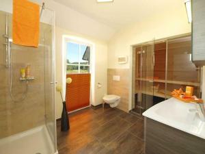 a bathroom with a shower and a toilet and a sink at Ferienhaus Strandmuschel mit Sauna in Loddin +12 photos