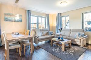 a living room with a couch and a table at Ferienhaus Strandmuschel mit Sauna in Loddin
