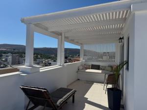a white pergola on a balcony with a table and chairs at Melina Knossos Iraklio Crete in Áno Fortétsa