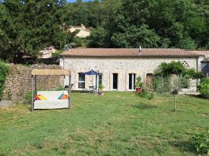 a stone house with a table in a yard at Les Jardins du Bateau in Vals-les-Bains