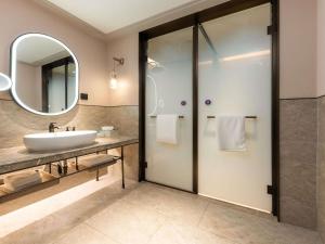a bathroom with a sink and a mirror at Mercure Danzhou Yangpu Seaview in Dongshan +68 photos
