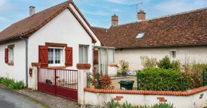 a white house with red doors and a fence at Caporizon - La Solognote in Bracieux