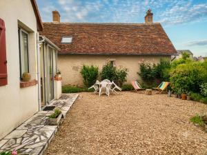 a patio with chairs and a table in front of a house at Caporizon - La Solognote in Bracieux