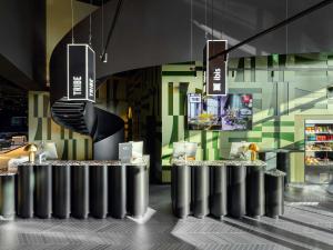 a restaurant with a row of silver tables with lights at TRIBE Budapest Stadium in Budapest