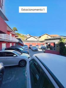 a row of parked cars in a parking lot at Suites CAMINHO DA FÉ in Campos do Jordão