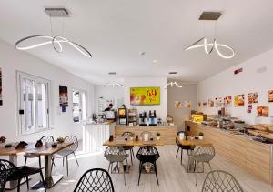 a restaurant with tables and chairs and a counter at chiAma Hotel in Rimini