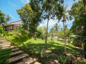 a garden with stairs and trees in front of a house at Casa Srithanu in Ko Phangan +2 photos