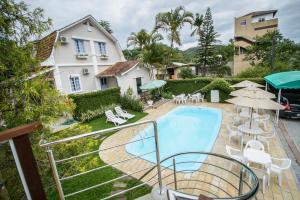 a balcony with a swimming pool and a house at Hotel Blumenhof in Blumenau