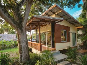a house with a wrap around porch with a tree at Casa Srithanu in Ko Phangan
