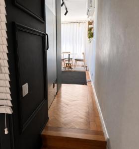 a hallway with a black door and a table at Casa da Loja in Marinha Grande