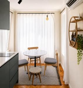 a small kitchen with a table and two chairs at Casa da Loja in Marinha Grande