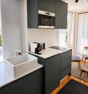 a kitchen with a sink and a microwave at Casa da Loja in Marinha Grande