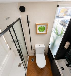 a small bathroom with a toilet and a shower at Casa da Loja in Marinha Grande +10 photos