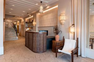 a lobby of a hotel with a chair and a counter at Crisol Lumière in Cannes