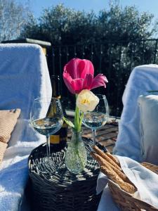 a pink flower in a vase on a table with glasses at Villa Burzio 1899 in Chieri