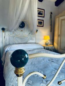 a bedroom with a white bed with a white canopy at Villa Burzio 1899 in Chieri