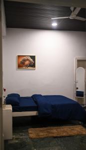 a bedroom with a bed with blue sheets and a ceiling at Lighthouse Villa Homestay in Dimapur