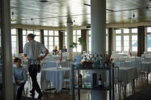 a man and a child standing in a dining room with tables at Grand Hôtel Mölle in Mölle +29 photos