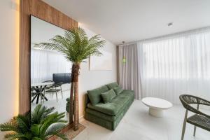 a living room with a green chair and a palm tree at Albir Experience in Albir