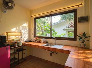 a kitchen with a sink and a large window at Casa Srithanu in Ko Phangan