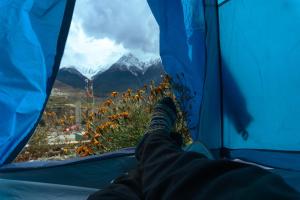 a persons feet in a tent looking out at a mountain at Hotel Sakura in Jomsom
