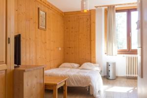 a bedroom with a bed in a room with wooden walls at Résidence La Grande Cordée - Combloux in Combloux