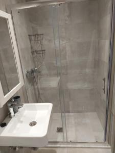a shower with a glass door next to a sink at Sky Rooms in Nea Kallikrateia +18 photos