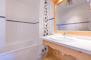 a bathroom with a sink and a mirror and a tub at Résidence La Grande Cordée - Combloux in Combloux +107 photos